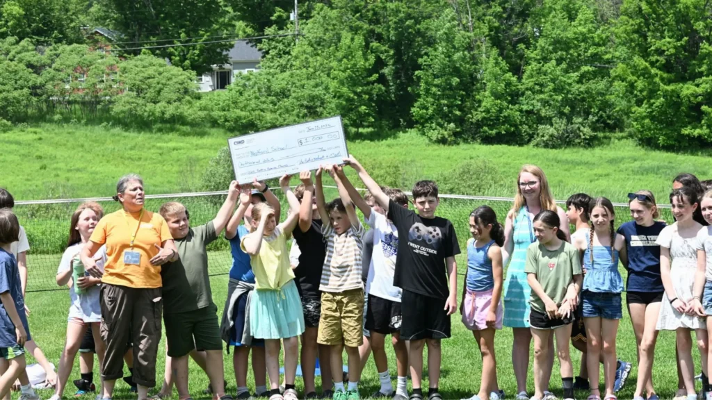 Kids celebrating and holding a giant check