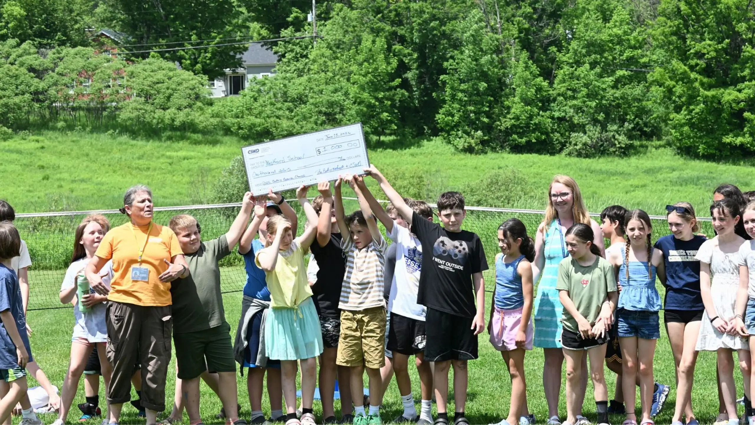 Kids celebrating and holding a giant check