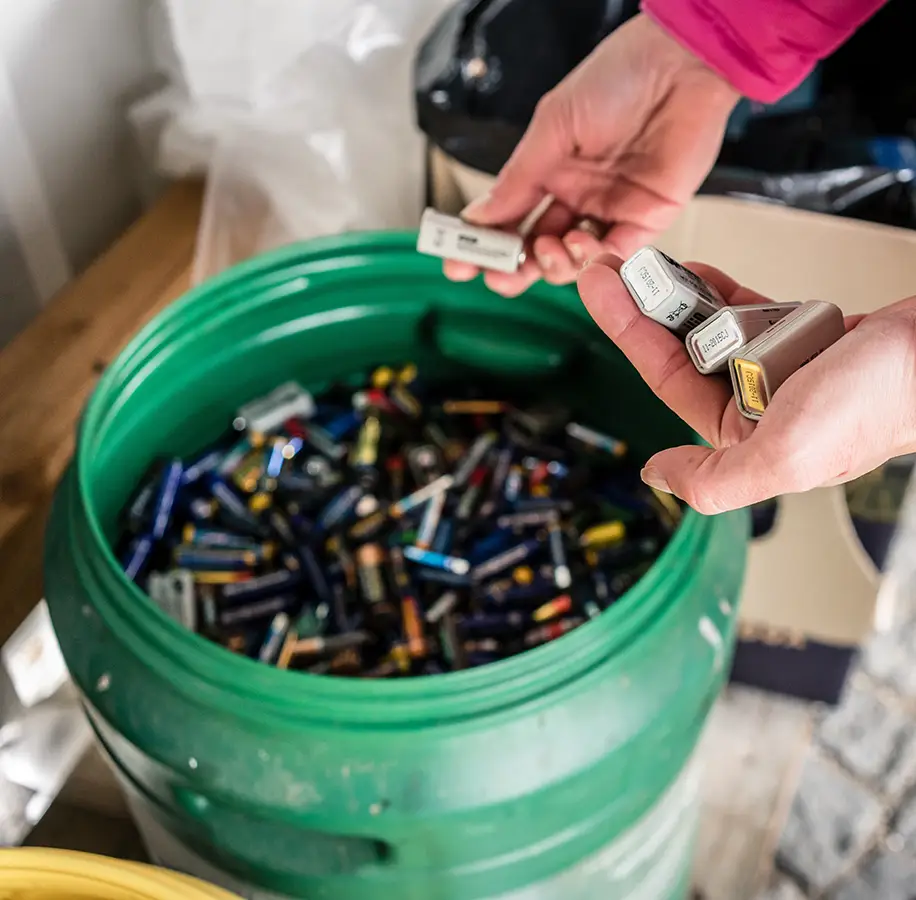 Batteries being sorted and placed in a bin